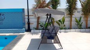 a chair under an umbrella next to a pool at aroya in Jeddah
