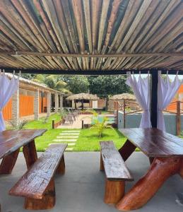 a group of picnic tables under a wooden umbrella at Pousada Jalapão Sunset in Mateiros