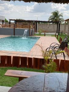 a swimming pool with a bench and a fountain at Pousada Jalapão Sunset in Mateiros