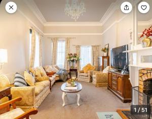 een woonkamer met een bank en een tafel bij Blackwood House in Healesville