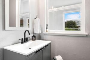 a white bathroom with a sink and a window at King Bed, Near DT and Best Restaurants, Pets OK! in Tacoma +57 photos
