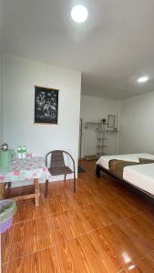 高兰Baanlek Guest House的一间卧室，有两张床和木地板