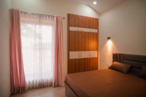 Un dormitorio con una cama y una ventana grande en Girivan, en Alwar 30 fotos más