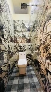 a bathroom with a toilet in a stone wall at Mountain Pearl Villa in Avathi