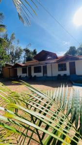 a house with a palm tree in front of it at Mountain Pearl Villa in Avathi