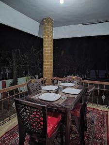 a wooden table and chairs on a patio at Mountain Pearl Villa in Avathi