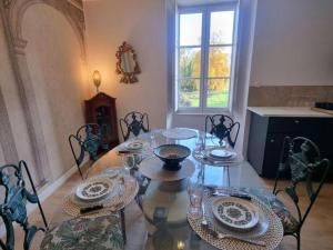 a dining room with a glass table and chairs at Gîte paisible dans château avec jardin en Auvergne - FR-1-489-604 in Louchy-Montfand
