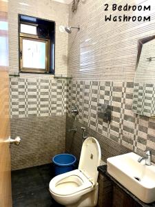 a bathroom with a toilet and a sink at Candy Stay's 2BHK with Pvt Pool in Lonavala +5 photos