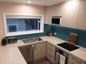 a small kitchen with a sink and a window at Sweet on Sutton in Richmond