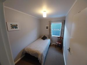 a small bedroom with a bed and a window at Sweet on Sutton in Richmond
