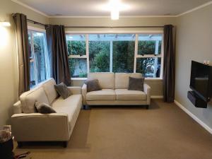 a living room with two couches and a tv at Sweet on Sutton in Richmond