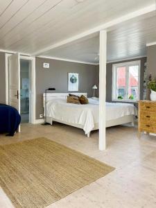 Un dormitorio con una gran cama blanca en una habitación. en Historic Halland Farm Near The Sea In Bua, en Väröbacka