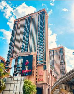 een hoog gebouw met een bord ervoor bij Eco suites at times square in Kuala Lumpur
