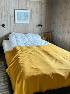 un letto con una coperta gialla sopra di Nature-Close Cabin By The Water a Eggedal