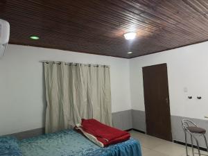 a bedroom with a bed and a wooden ceiling at Quarto Suite in Mucugê