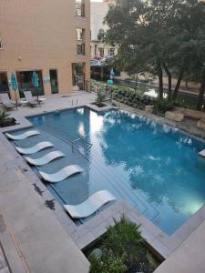 einen großen Pool mit Liegestühlen neben einem Gebäude in der Unterkunft Riverwalk Luxury Haven Pool Free Parking in San Antonio