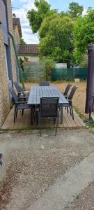 a picnic table and chairs on a wooden deck at Casa Ginguba in Saint-Émilion