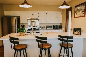 a kitchen with a large white island with bar stools at Breck Ski Chalet, Pet Friendly, Private Hot Tub and Scenic Views in Breckenridge