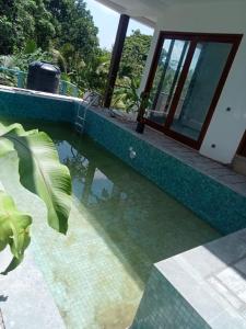 a swimming pool next to a house at Moon Lanka Hotel in Hikkaduwa