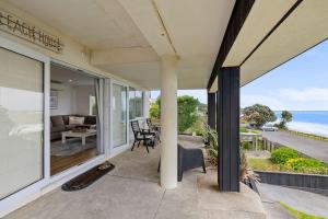 a house with a balcony with a view of the ocean at Wow On Wanaka Bay - beachfront living at its best in New Plymouth