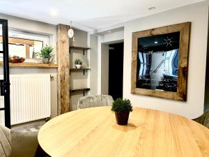 a dining room with a wooden table with a potted plant at Bramasole - Wohnung mit Carport in Cottbus