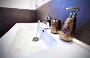 een wastafel in de badkamer met een kraan en een zeepdispenser bij Villa Anna in Quartu Sant'Elena +22 foto's