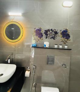 a bathroom with a sink and a toilet and a mirror at KiwiOz Villa in Thamarassery