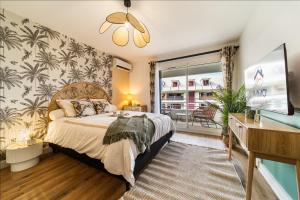 a bedroom with a bed and a desk at L Escapade - Studio tropical chic et parking prive in Saint-Denis