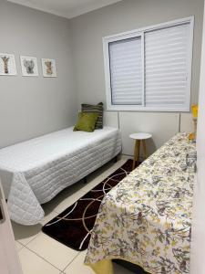 a bedroom with two beds and a window at Apartamento em Bertioga, ótima localização, Bertioga Residence Club in Bertioga +45 photos