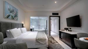 una habitación de hotel con una cama y un baño en Forest Hills Hotel, en Soreang