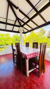 a dining room table with a red and white checkered table cloth at Wasana Ocean View Villa Mirissa in Mirissa