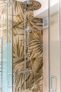a shower in a bathroom with a tropical wallpaper at L Escapade - Studio tropical chic et parking prive in Saint-Denis +8 photos