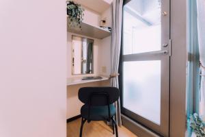 Habitación con silla y ventana en Stylish Minimalist Loft 7 & Gym in Namba Compact Studio 5, en Wada