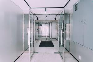 a corridor of glass doors in an office building at Stylish Minimalist Loft 7 & Gym in Namba Compact Studio 5 in Wada