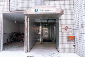 an entrance to a building with a sign on it at Stylish Minimalist Loft 7 & Gym in Namba Compact Studio 5 in Wada +13 photos