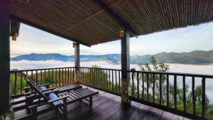 a porch with a chair and a view of the mountains at A Su Homestay Mù Cang Chải in Mù Cang Chải