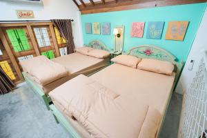 une chambre avec trois lits dans une pièce dans l'établissement Pilar Guest House Jogja, à Ngemplak