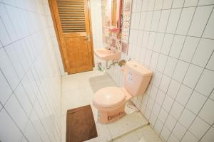 une salle de bains avec toilettes et lavabo dans l'établissement Pilar Guest House Jogja, à Ngemplak 40 autres photos