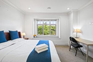 a bedroom with a large bed with a desk and a window at 1 Bedroom Luxury Retreat in Prime Vancouver in Vancouver