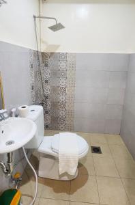 Un baño con un inodoro blanco y un lavabo. en Hey Mojo Guest House by Bantayan Summerhouse, en Pooc