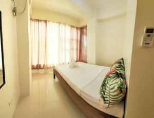 Un dormitorio con una cama y una ventana con cortinas. en Hey Mojo Guest House by Bantayan Summerhouse, en Pooc