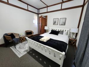 Un dormitorio con una gran cama blanca y una silla. en Bowen Toft Villa- New Listing, en Sandy Bay