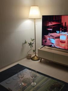 two wine glasses sitting on a table in front of a tv at Stay EROB in Seoul