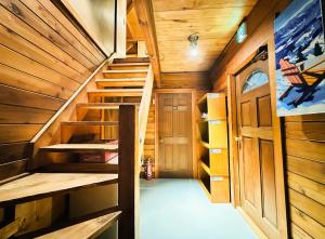 a staircase in a cabin with wooden walls at The Capsule Hakuba in Hakuba