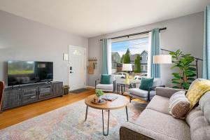 a living room with a couch and a tv at Walk to Dining & Waterfront, Spacious with Best Beds in Tacoma