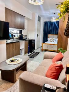 Una sala de estar con un sofá y una mesa y una cocina. en Zury Suites, en Nairobi