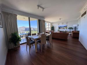 a living room with a table and chairs and a couch at Canberra City View Apartment in Canberra +31 photos
