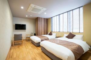 a hotel room with two beds and a tv at Hotel S-Presso Namba Ekimae in Osaka +33 photos