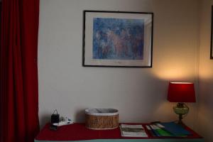 a room with a table with a lamp and a picture at Gite le GINKGO 50 M2 in Rougegoutte