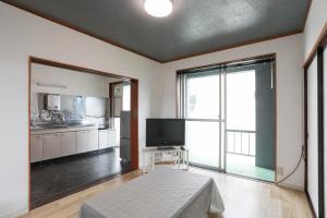 a living room with a large window and a television at ひだまりの宿 まゆしょう in Wada +29 photos